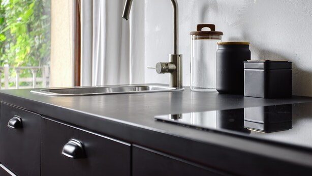 A kitchen with a stainless steel faucet, a clear glass container with a lid, and a black appliance on the counter. - JOIVY Superb Studio In The Centre Of Milan (Milan)