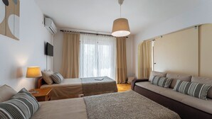 A hotel room with two beds, a sofa, a lamp, and a TV. - Rosy in Rovinj - Istrien / Rosy in Rovinj - Appartement für 4-6 Personen (Rovinj)