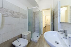 A modern bathroom with a large sink, two basins, a shower enclosure, and a toilet. - JOIVY Rosa’S Home (Rapallo)