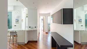 Eine moderne Küche mit Marmorarbeitsplatte, Holzboden und einer Sitzbank.