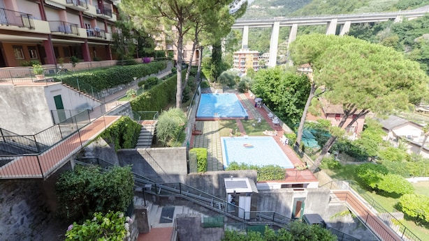 A residential area with a swimming pool, stairs, and a bridge in the background.