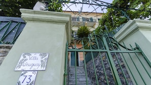 Ein begrenzter Eingangsbereich mit einem Schild, auf dem 'Villa Uruguay 73' steht, und einer Treppe, die nach oben führt.