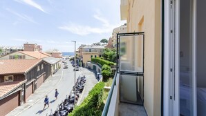 A balcony with a view of a street, parked motorcycles, and buildings. - JOIVY Two Steps From The Sea In Genoa (Genoa)