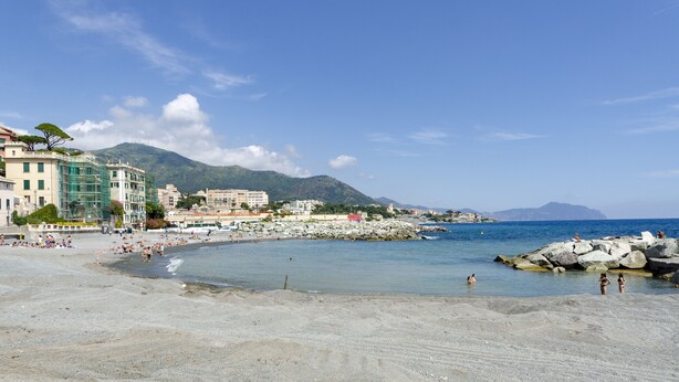 A beach with buildings, rocky shoreline, and clear blue sky. - JOIVY Two Steps From The Sea In Genoa (Genoa)