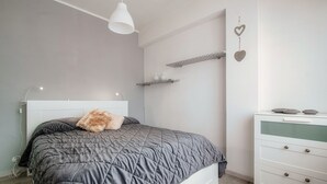 A bedroom with a bed, bedside table, and a dresser. - JOIVY Family Flat W/Balcony (Como)