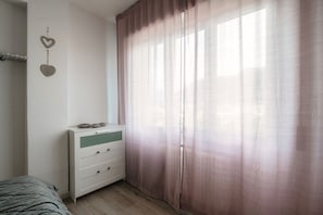 Cozy retreat with a single bed, dresser, and heart-shaped wall decorations.