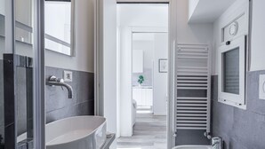 A modern bathroom with a large sink, a bathtub, and a shower area.