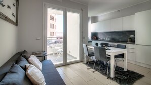Eine moderne Wohnung mit Essbereich, einer Couch und einer Küche.