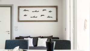 Ein modernes Wohnzimmer mit einer Couch, einem Couchtisch und einem gerahmten Motivationsspruch an der Wand.