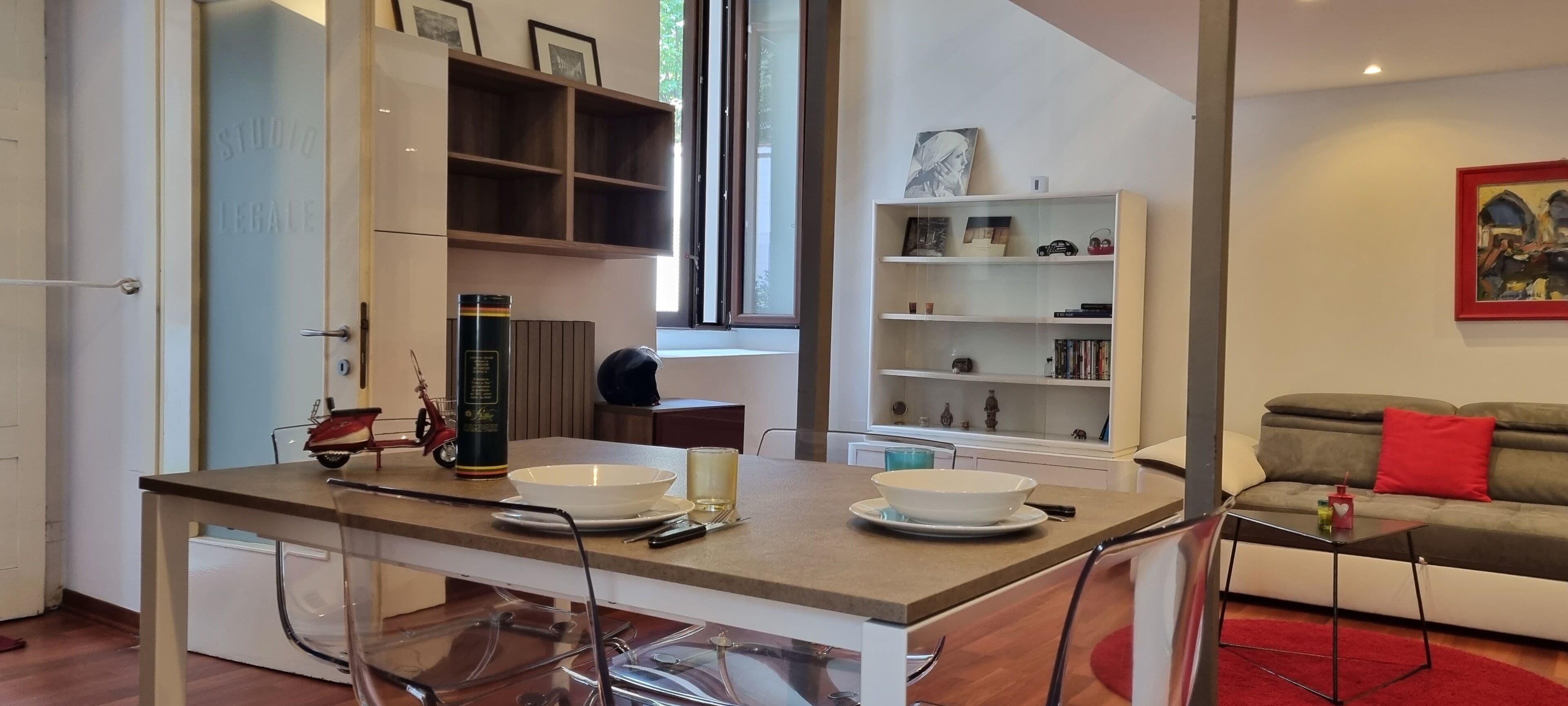 Un salon moderne comprenant un coin repas, une bibliothèque et un canapé.