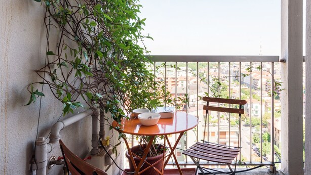 A balcony with a table, chairs, and a potted plant. - JOIVY Homey 1-Bed W/View Near Citylife (Milan)