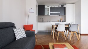 A modern living room with a grey sofa, a red pillow, and a wooden coffee table. - JOIVY Superb Flat W/Home Office (Milan)