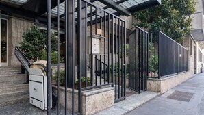 A building with a gated entrance, a staircase, and a parked vehicle. - JOIVY Superb Flat W/Home Office (Milan)