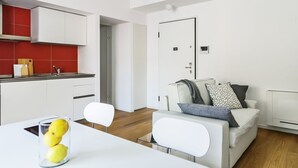 A modern apartment with a kitchen, dining area, and living room. - JOIVY Stylish 1-Bedroom Flat (Milan)