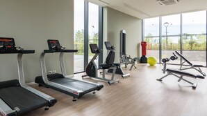 A gym with treadmills, elliptical machines, and weightlifting equipment.