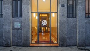 Une entrée d’immeuble avec une porte en verre portant le numéro 43.