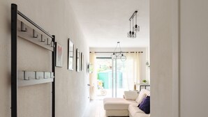 A hallway with a white sofa, a door, and a view to an outdoor area. - JOIVY Flat W/Terrace & Parking (Sestri Levante)