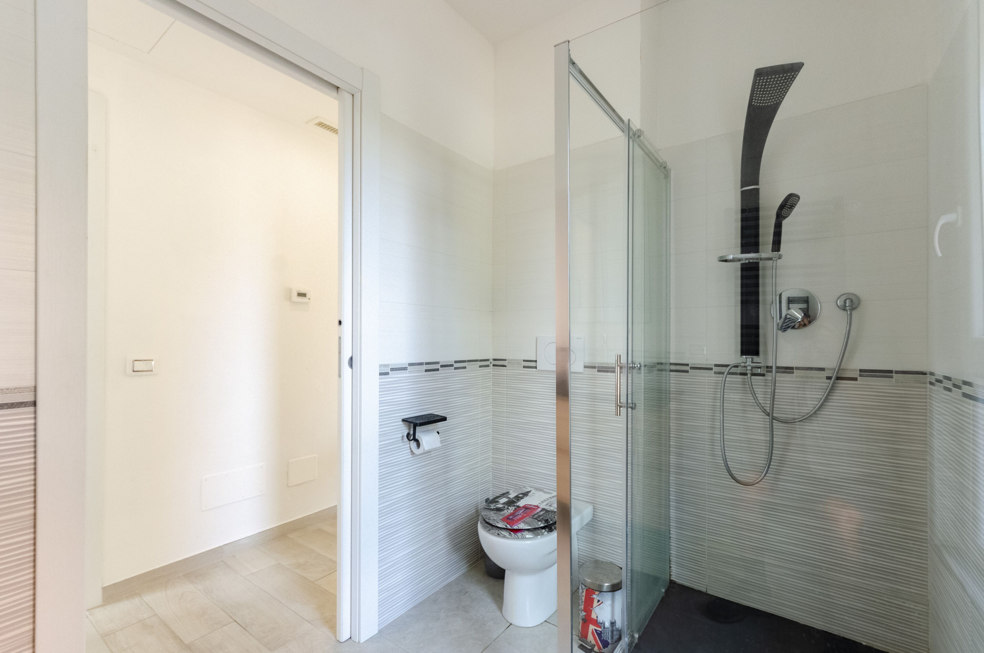 Une salle de bain moderne avec une douche à parois de verre, des toilettes et un lavabo.