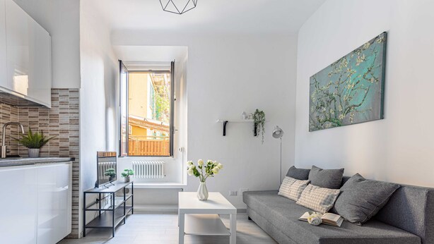 A modern apartment with a kitchen, a dining area, and a living room. There is a window providing a view of the outside. - JOIVY Cosy 1-Bed Flat In Navigli (Milan)