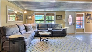 A living room with a sectional sofa, a small round table, and a patterned rug. - 4 Palms by Silver Sands Vacation Rentals (Port Aransas)