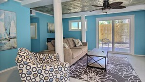 A living room with a beige sofa, patterned armchair, and a coffee table. - 4 Palms by Silver Sands Vacation Rentals (Port Aransas)