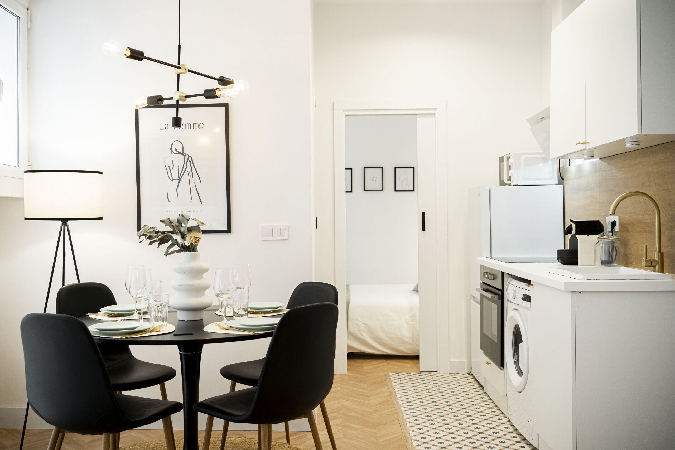A modern kitchen with white cabinetry, a built-in oven, and a microwave.