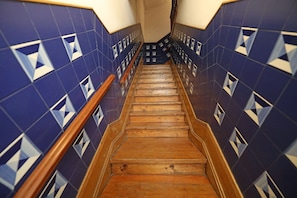 A wooden staircase with blue and white patterned walls.