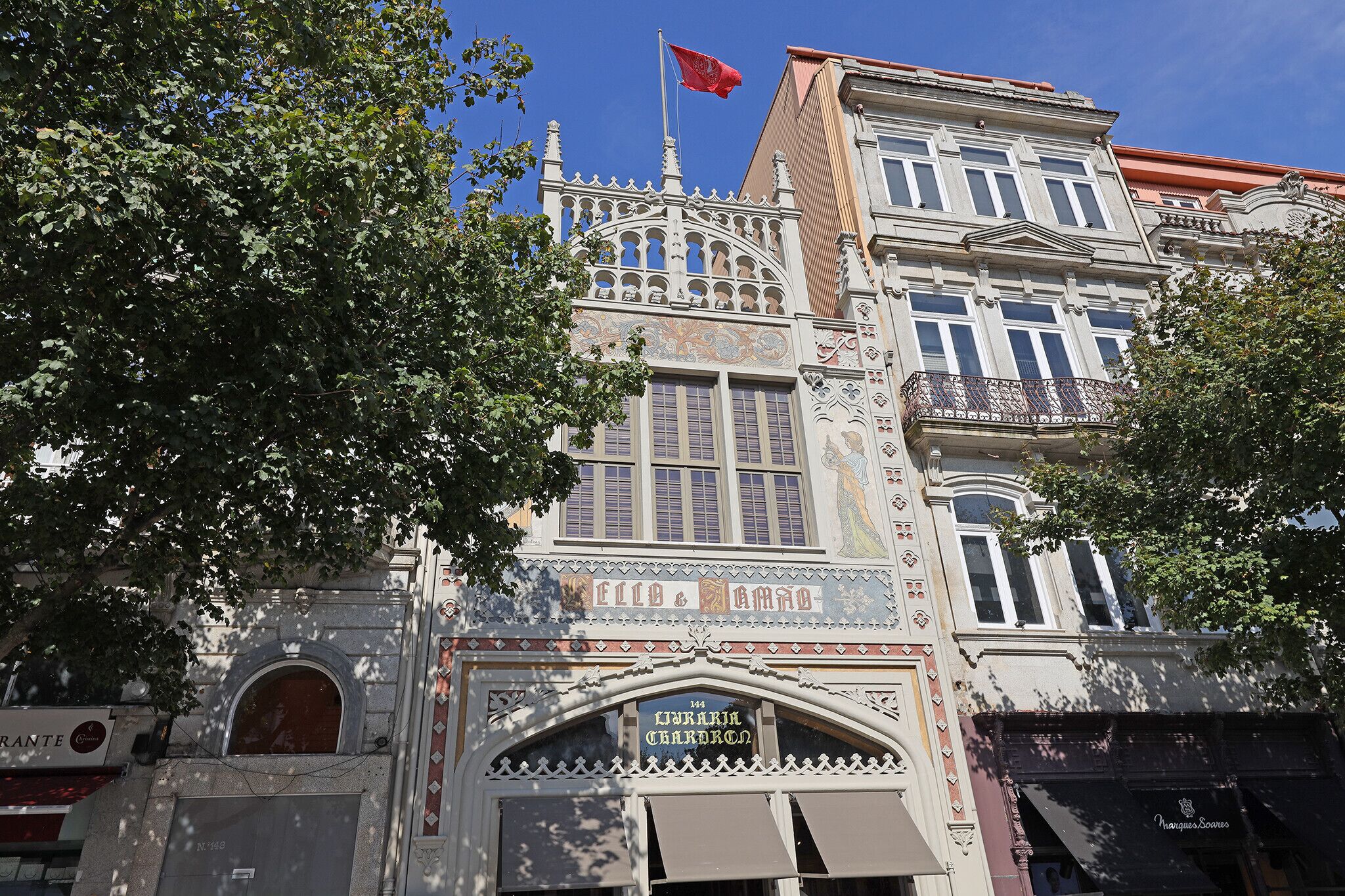 A historic building with ornate architecture, including a balcony and a flag.