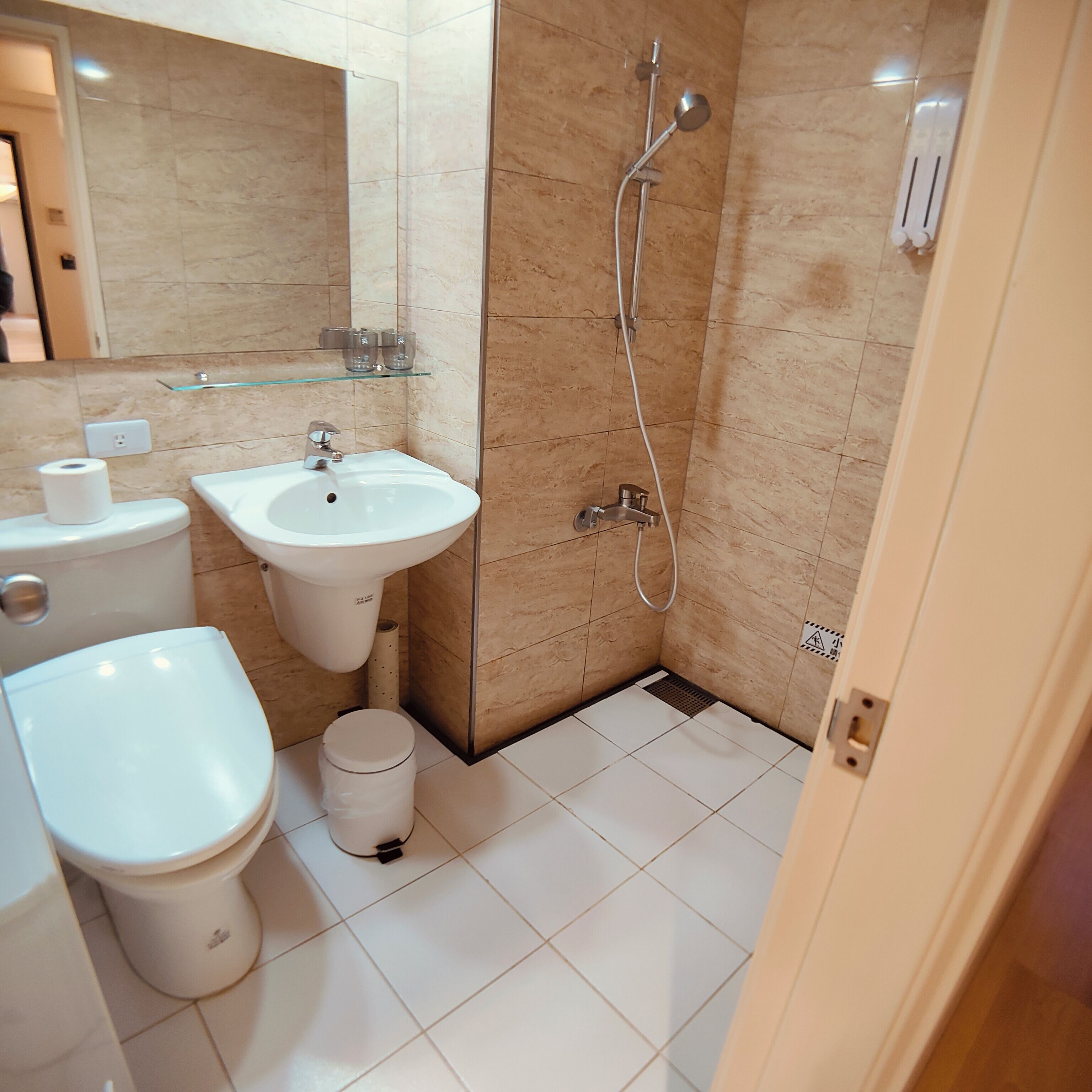 A modern bathroom with a toilet, sink, and shower.