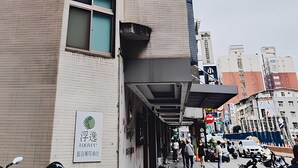 A hotel with a modern facade, a prominent sign indicating self-assistance, and a visible entrance with people and vehicles. - FooYee Hotel-YongHe (New Taipei City)