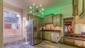 A kitchen with green cabinets, a stainless steel refrigerator, and a granite countertop. - Funky Memphis Game House! FirePit, Gtd pkg, Games! (Memphis)