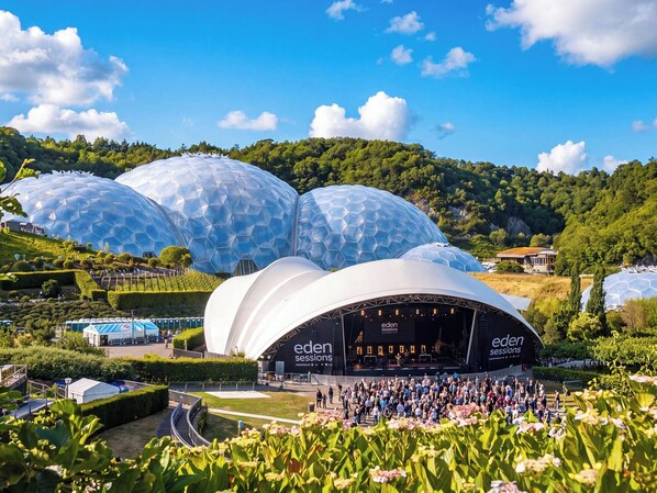 A large open-air venue with a stage labeled 'eden sessions' and a crowd gathered in front.