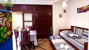 A room with a dining table, chairs, a sofa, and a ceiling fan. - Residencial Bem te vi (Jijoca de Jericoacoara)