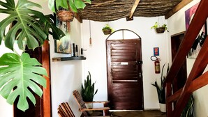 A wooden door with a metal latch, a rustic ceiling, and various potted plants. - Residencial Bem te vi (Jijoca de Jericoacoara)