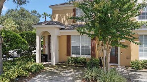A two-story house with a front porch, a garage, and a well-maintained garden.
