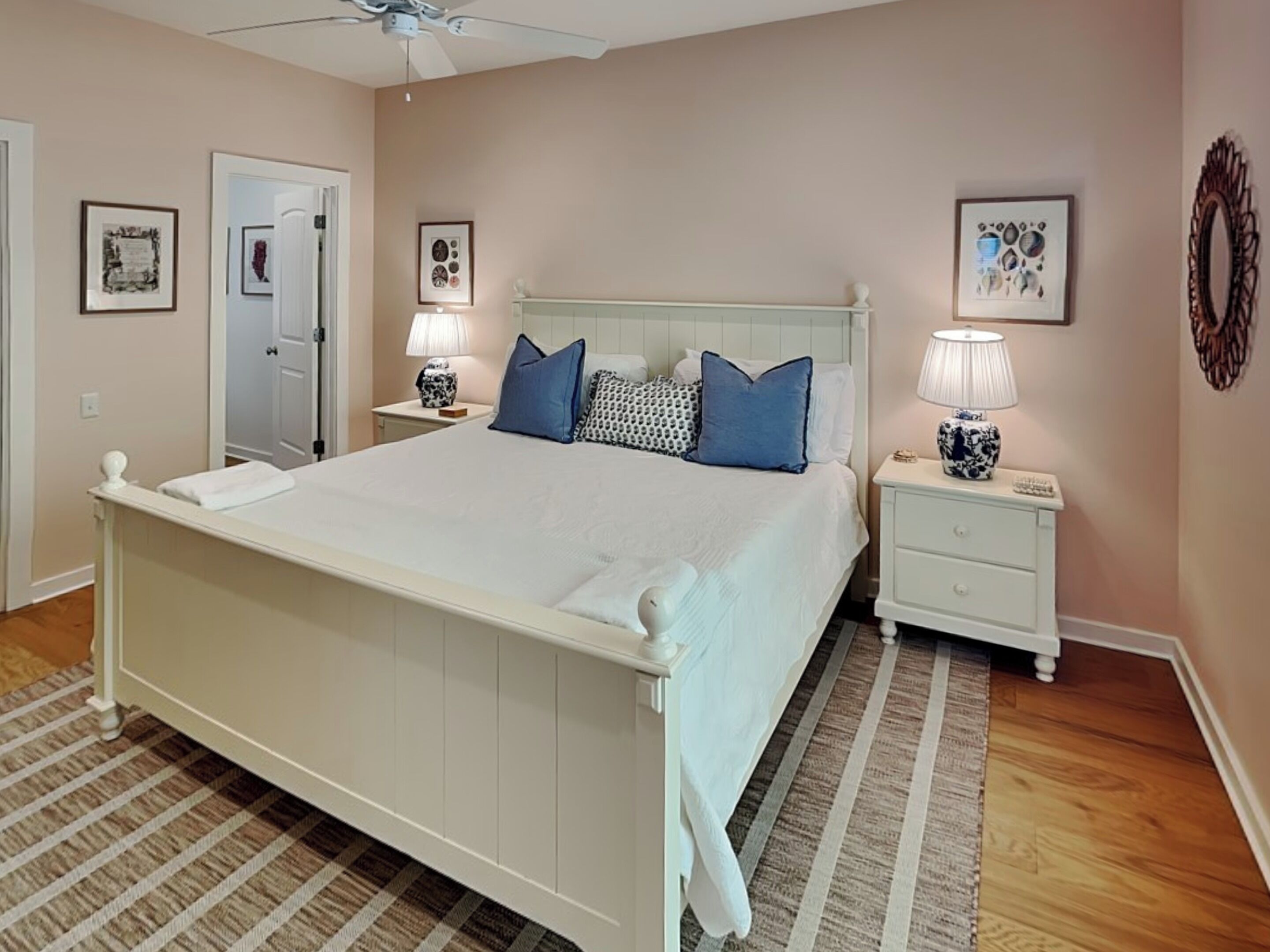 A neatly arranged bedroom with a large bed, bedside tables, and a ceiling fan.