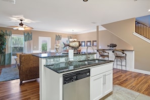 A kitchen with a central island, a dishwasher, and a ceiling fan.