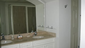 A bathroom with two sinks, a large mirror, and a door. - CONDO MARINA G  BY TRVL2HM (Nuevo Nayarit)