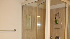 A bathroom with a toilet, a glass-enclosed shower, and a towel rack. - CONDOMINIO GRAND MARINA by TRVL2HM (Nuevo Nayarit)