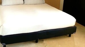 A bed with a white mattress and two pillows, a dark headboard, and a beige wall. - CONDO BAL BY TRVL2HM (Nuevo Nayarit)