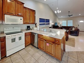 A modern kitchen with wooden cabinets, a white stove, and a dishwasher.