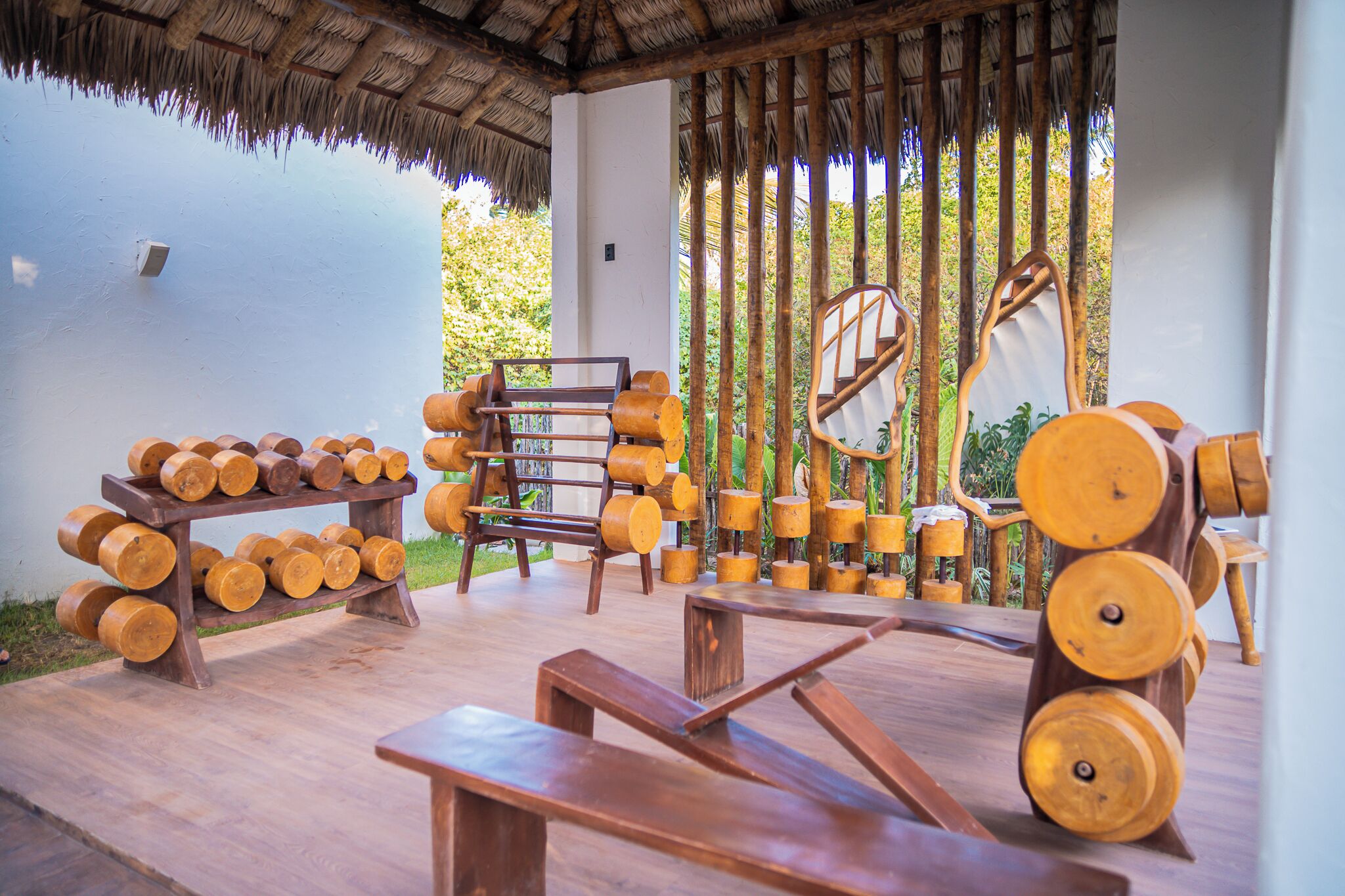 A wooden outdoor seating area with benches and a wooden structure with cylindrical logs.