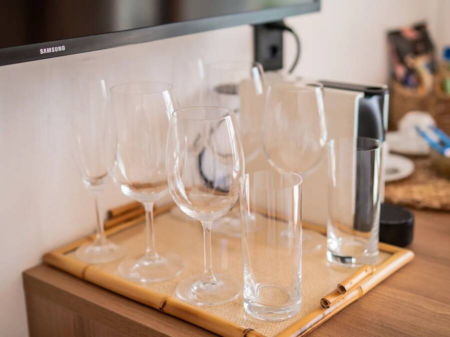 Una encimera de cocina con varias copas de vino vacías y una cafetera.
