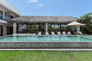 Una piscina al aire libre, tumbonas