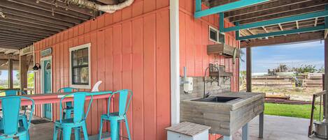 Un coin bar au style rustique, avec des chaises turquoise, un comptoir en bois et un panneau indiquant « BOÎTES DE CONSERVE ».