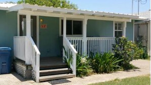 A single-story house with a porch, a mailbox, and a small garden. - Cape Cod Cottage by Silver Sands Vacation Rentals (Port Aransas)