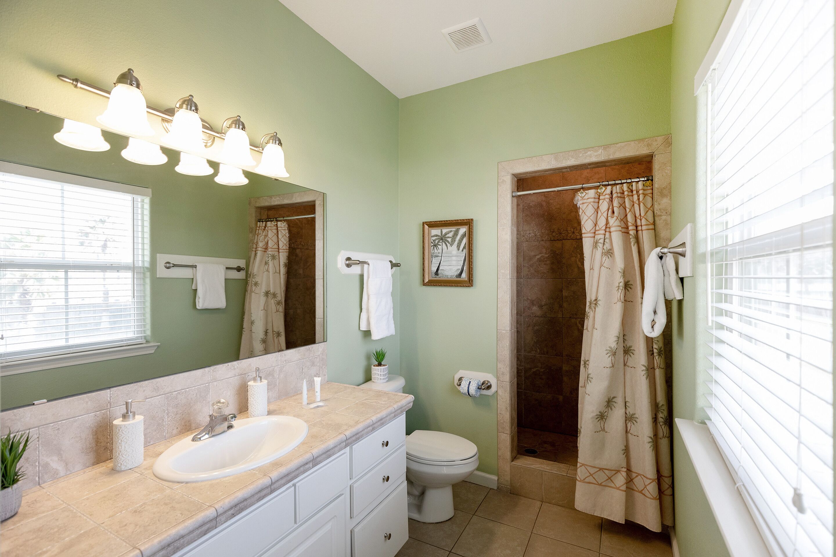 A bathroom with a sink, toilet, and shower area.