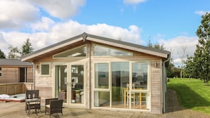 Ein modernes Haus mit Terrasse, Glasüren und einer Patio.