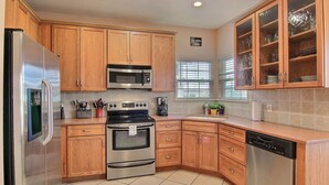 A kitchen with wooden cabinets, stainless steel appliances, and a dishwasher.