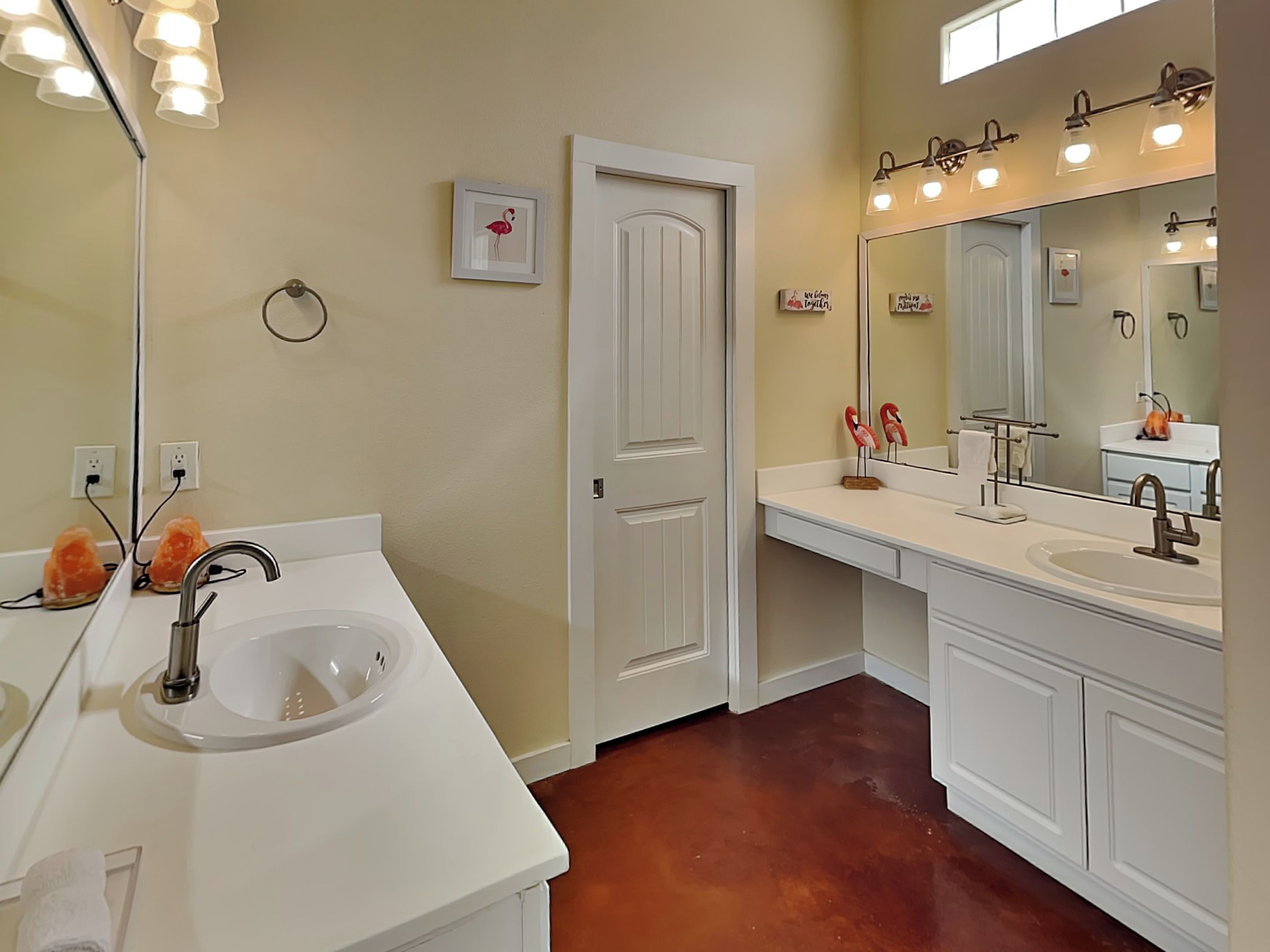 A bathroom with two sinks, a large mirror, and a door.